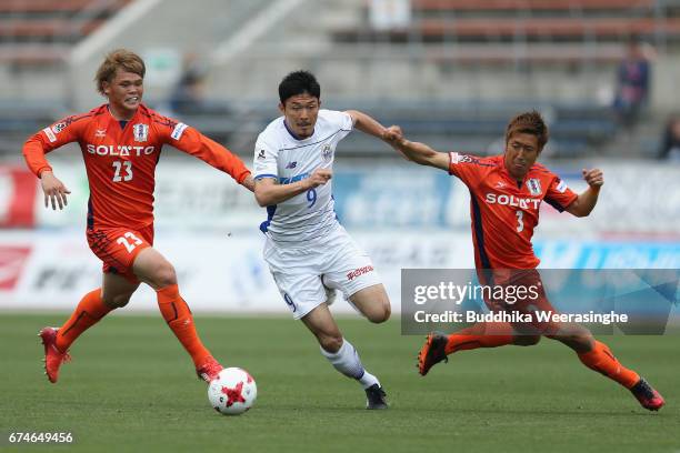 Yuji Senuma of Montedio Yamagata competes for the ball against Makoto Rindo Mutsumi Tamabayashi of Ehime FC during the J.League J2 match between...