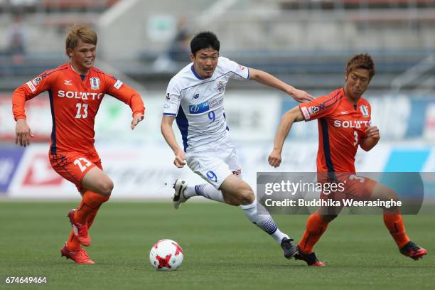 Yuji Senuma of Montedio Yamagata competes for the ball against Makoto Rindo Mutsumi Tamabayashi of Ehime FC during the J.League J2 match between...