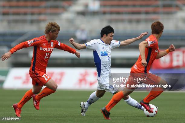 Yuji Senuma of Montedio Yamagata competes for the ball against Makoto Rindo Mutsumi Tamabayashi of Ehime FC during the J.League J2 match between...