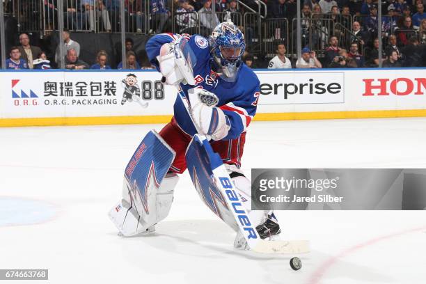 Henrik Lundqvist of the New York Rangers plays the puck against the Montreal Canadiens in Game Six of the Eastern Conference First Round during the...