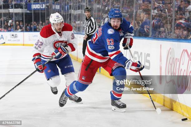 Mika Zibanejad of the New York Rangers skates with the puck against Brian Flynn of the Montreal Canadiens in Game Six of the Eastern Conference First...