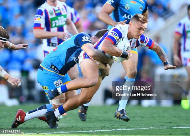 Daniel Levi of the Knights is tackled by Ryan Simpkins of the Titans during the round nine NRL match between the Gold Coast Titans and the Newcastle...