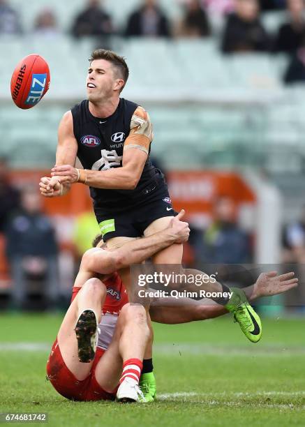 Marc Murphy of the Blues handballs whilst being tackled during the round six AFL match between the Carlton Blues and the Sydney Swans at Melbourne...