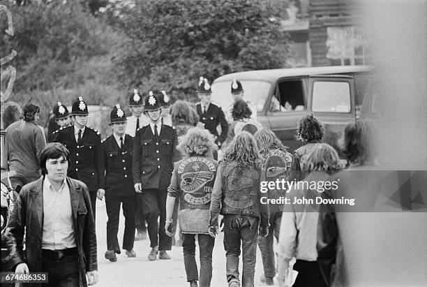 The Essex Hell's Angels and the local police pass each other at the Weeley Rock Festival near Clacton in Essex, UK, 29th August 1971.