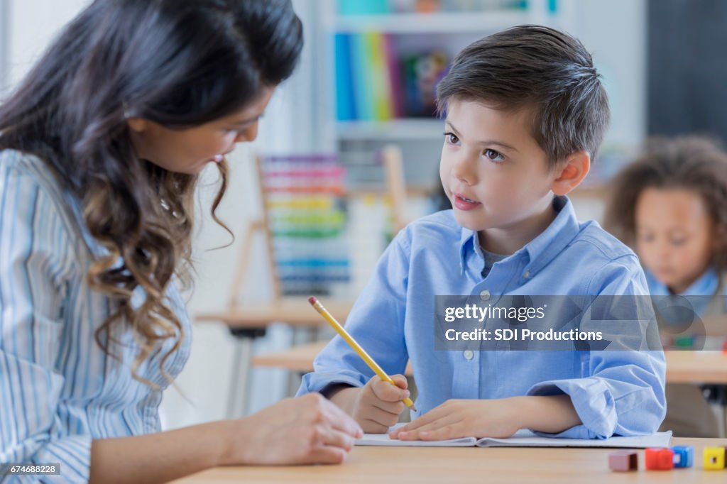 Young schoolboy works with his teacher at school