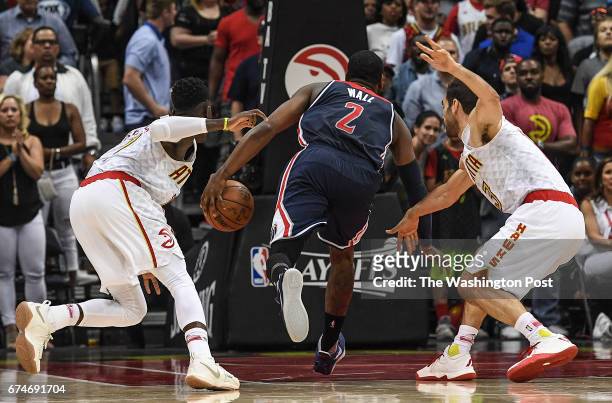 Washington Wizards guard John Wall runs between Atlanta Hawks guard Dennis Schroder , left, and Atlanta Hawks guard Jose Calderon , right, on his way...