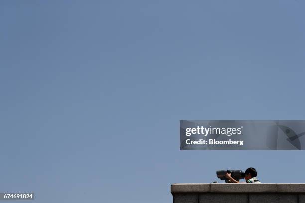 Visitor using a binocular looks at the North Korean village of Gaepung-Gun at the Odusan Unification Observatory near the Demilitarized Zone in Paju,...