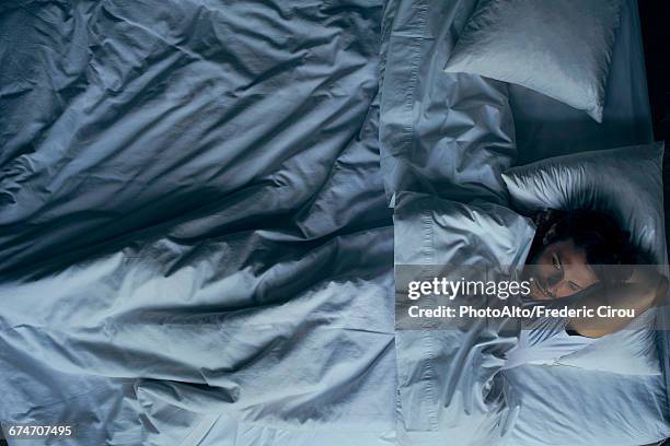 man lying in bed - above view of man sleeping on bed stock-fotos und bilder