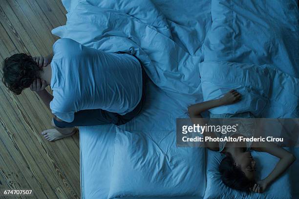 man unable to sleep while wife sleeps comfortably unaware - insomnia 個照片及圖片檔