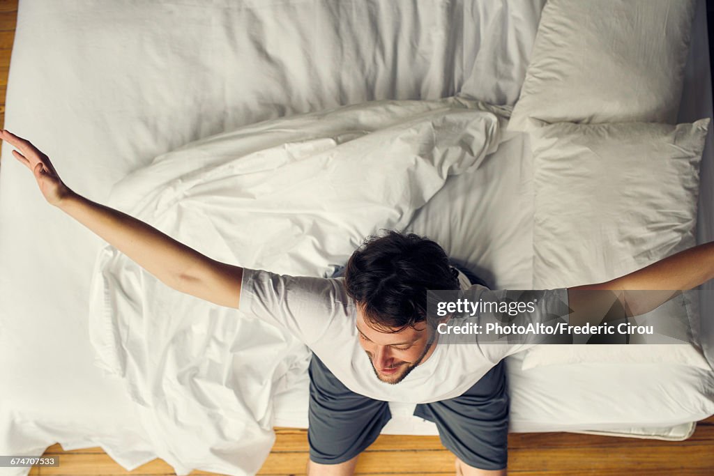 Man stretching in bed