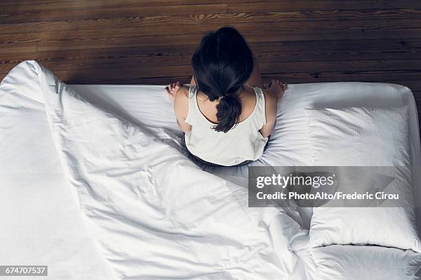 woman sitting on edge of bed waking up - bachelorette stock pictures, royalty-free photos & images