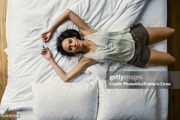 woman lying in bed stretching - fatigue full body stock-fotos und bilder