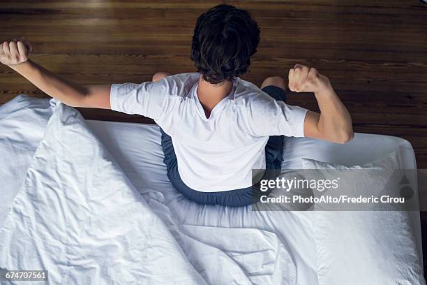 man stretching as he wakes up - morning bed stretch fotografías e imágenes de stock