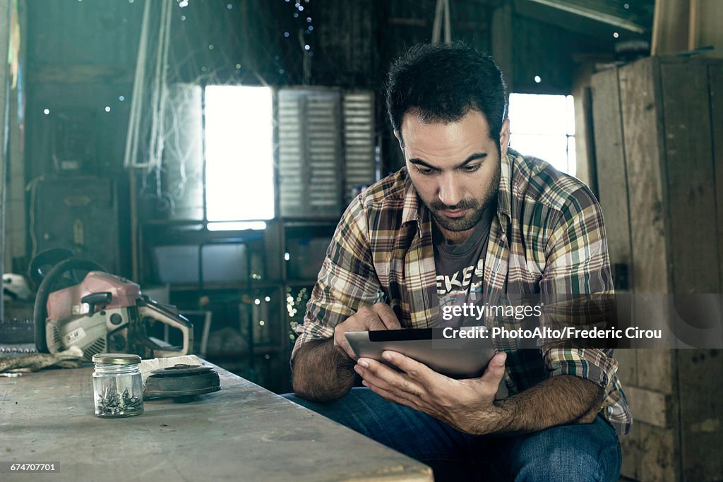Man using digital tablet to access internet during break from work