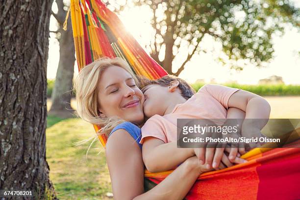 mother and son relaxing together in hammock - 面貼面 個照片及圖片檔