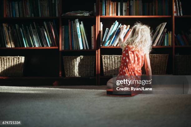 bambini che esplorano libri da leggere - bookshelf foto e immagini stock