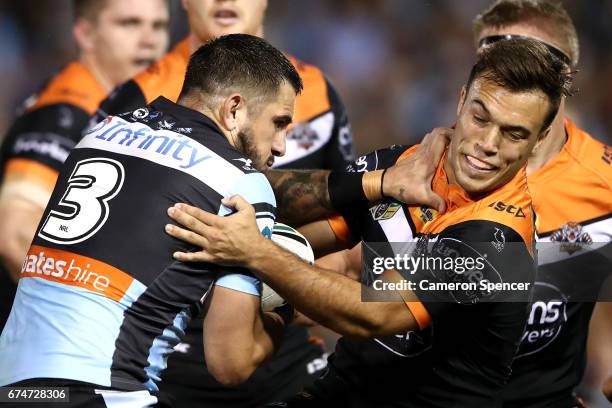 Jack Bird of the Sharks is tackled during the round nine NRL match between the Wests Tigers and the Cronulla Sharks at Leichhardt Oval on April 29,...