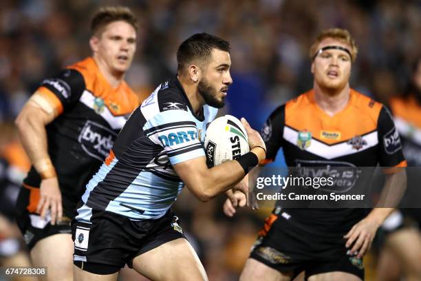 Jack Bird of the Sharks is tackled during the round nine NRL match between the Wests Tigers and the Cronulla Sharks at Leichhardt Oval on April 29,...