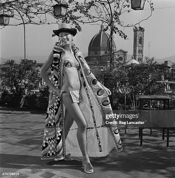 Model wearing a bikini cape by Emilio Pucci, in Florence, Italy, 18th October 1970. The dome and campanile of Florence Cathedral are visible in the...