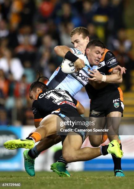 Chris Heighington of the Sharks is tackled during the round nine NRL match between the Wests Tigers and the Cronulla Sharks at Leichhardt Oval on...