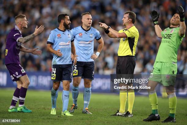 Andy Keogh and Liam Reddy of the Glory react and Alex Brosque and Jordy Buijs of Sydney FC watch on as referee Peter Green calls for a video referral...