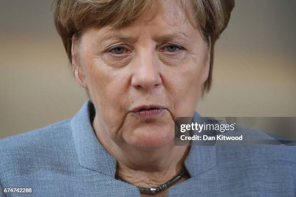 German Chancellor Angela Merkel speaks to the media as she arrives at the Council of the European Union ahead of an EU Council meeting on April 29,...