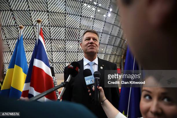 Romanian President Klaus Werner Iohannis speaks to the media as he arrives at the Council of the European Union ahead of an EU Council meeting on...
