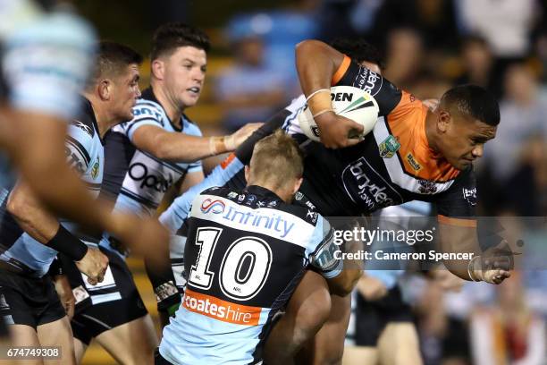 Avagalu Seumanufagai of the Tigers is tackled during the round nine NRL match between the Wests Tigers and the Cronulla Sharks at Leichhardt Oval on...