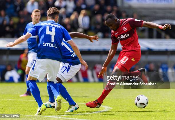 Jacques Zoua Daogari of FC Kaiserslautern challenges Martin Stoll of Karlsruhe during the Second Bundesliga match between Karlsruher SC and 1. FC...