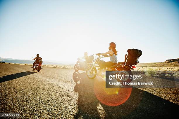 motorcyclists riding together along desert road - frau motorrad stock-fotos und bilder