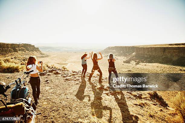 woman taking photo of friends with smartphone - motorcycle travel stock-fotos und bilder