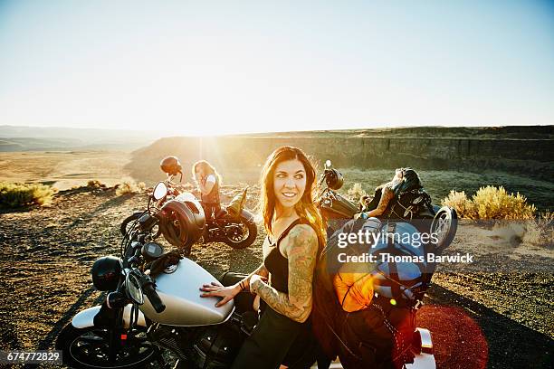 female motorcyclist at overlook during road trip - connect friends sunrise photos et images de collection