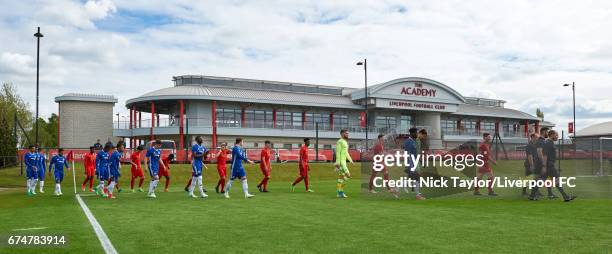 The Liverpool and Chelsea players make their way onto the pitch with the match officials before the Liverpool v Chelsea U18 Premier League game at...