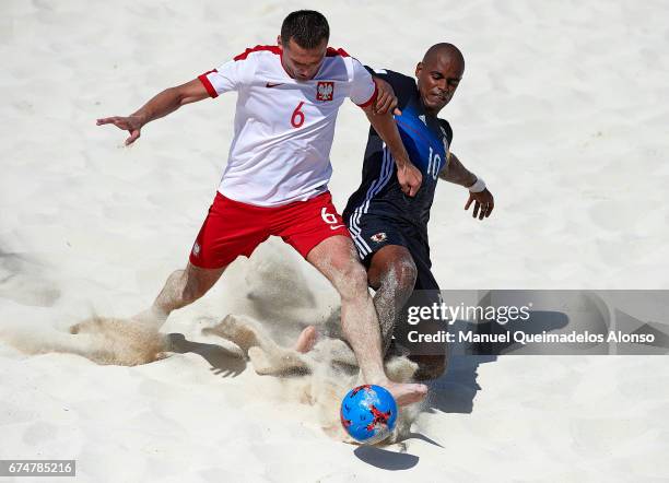 Jakub Jesionowski of Poland is tackled by Ozu Moreira of Japan during the FIFA Beach Soccer World Cup Bahamas 2017 group D match between Japan and...