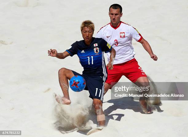 Takasuke Goto of Japan is closed down by Michal Labedzki of Poland during the FIFA Beach Soccer World Cup Bahamas 2017 group D match between Japan...
