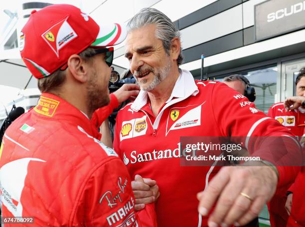 Ferrari Team Principal Maurizio Arrivabene congratulates pole sitter Sebastian Vettel of Germany and Ferrari in the Paddock during qualifying for the...