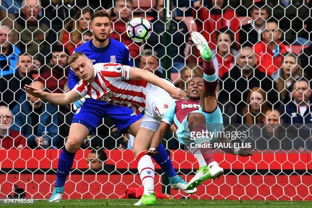 West Ham United's French-born Ghanaian midfielder Andre Ayew tries an overhaed a shot, which is saved by Stoke City's English goalkeeper Jack Butland...
