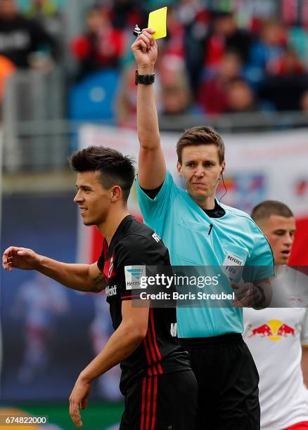 Referee Daniel Siebert shows the second yellow card in one game to Alfredo Morales of FC Ingolstadt 04 during the Bundesliga match between RB Leipzig...