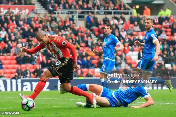 Bournemouth's English defender Steve Cook tires to tackle Sunderland's French-born Tunisian midfielder Wahbi Khazri during the English Premier League...