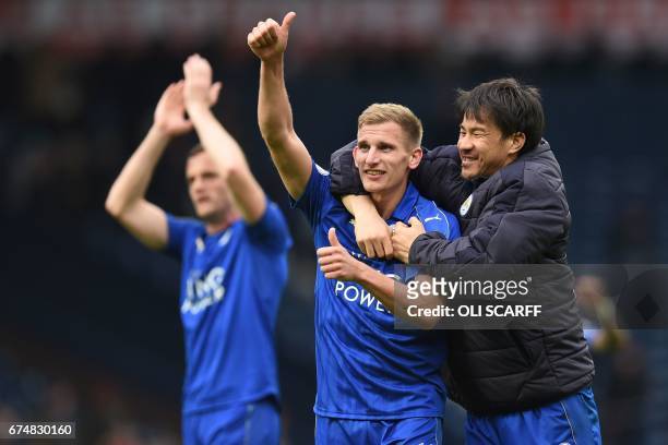 Leicester City's English midfielder Marc Albrighton and Leicester City's Japanese striker Shinji Okazaki celebrate on the pitch after the English...