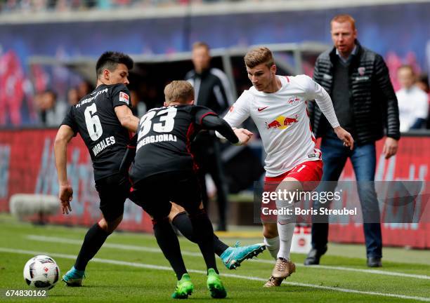 Timo Werner of RB Leipzig is challenged by Alfredo Morales and Florent Hadergjonaj of FC Ingolstadt 04 during the Bundesliga match between RB Leipzig...