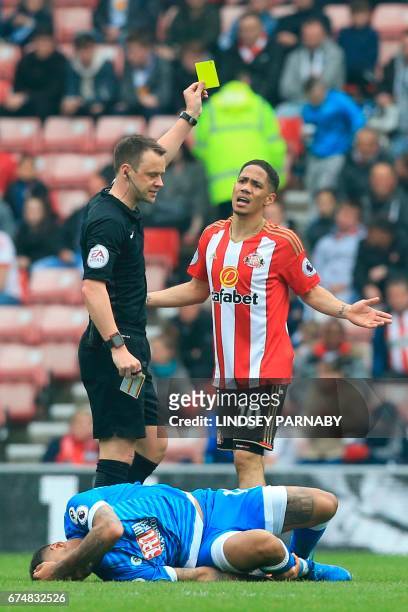 Sunderland's South African midfielder Steven Pienaar gets a yellow card from referee Stuart Attwell after a foul on Bournemouth's Norwegian striker...