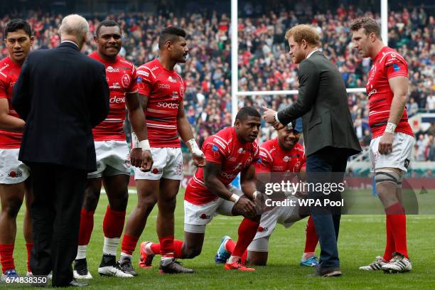 Players from the Army team kneel as Britain's Prince Harry greets the teams on the pitch ahead of the annual Army Navy armed forces rugby match at...