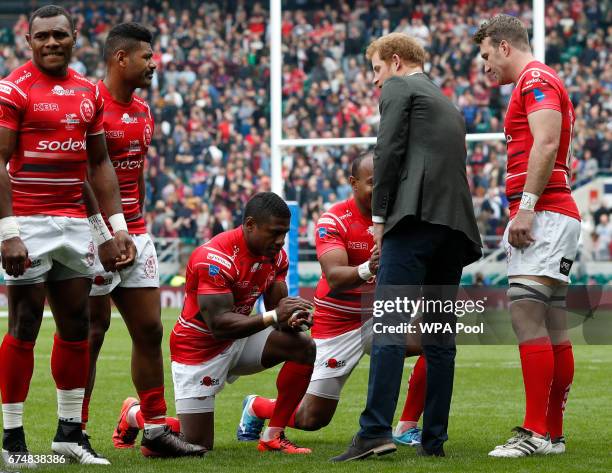 Players from the Army team kneel as Britain's Prince Harry greets the teams on the pitch ahead of the annual Army Navy armed forces rugby match at...