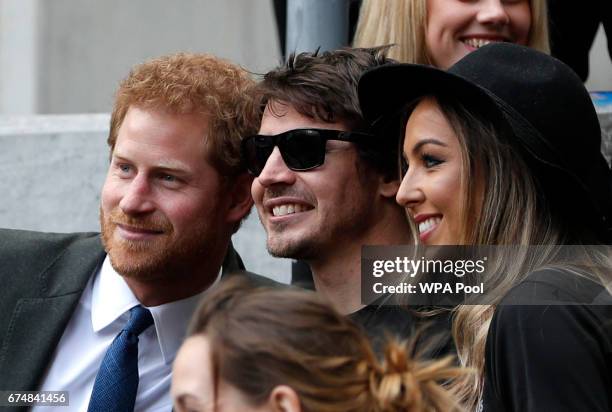 Britain's Prince Harry poses for a picture with competitors from the 2014 and 2016 Invictus Games in the crowd as he watches the annual Army Navy...