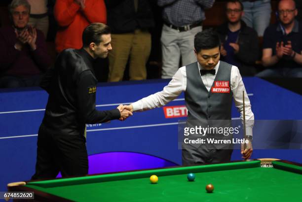 Mark Selby of England shakes hands with Ding Junhui of China after winning the semi final match on day fifteen of Betfred World Championship 2017 at...