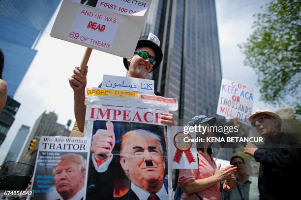 Man holds a banner as he takes part in the '100 Days of Failure' Protest as protesters mark the first 100 days of the administration of US President...