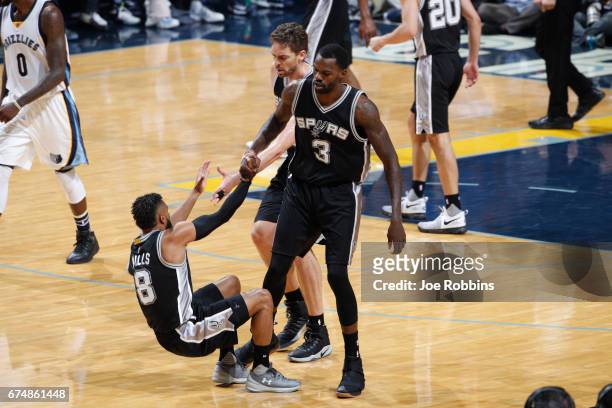 Dewayne Dedmon and Pau Gasol of the San Antonio Spurs help up Patty Mills of the San Antonio Spurs during the game against the Memphis Grizzlies...