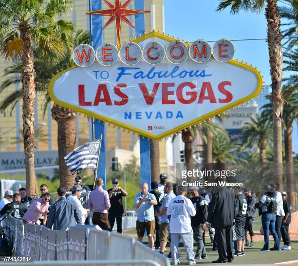 Oakland Raiders fans gather as the team selects draft picks in front of the Welcome to Fabulous Las Vegas sign on April 29, 2017 in Las Vegas,...