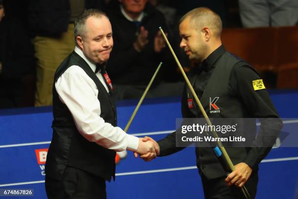 John Higgins of Scotland is congratulated by Barry Hawkins of England after winning their semi final match on day fifteen of Betfred World...